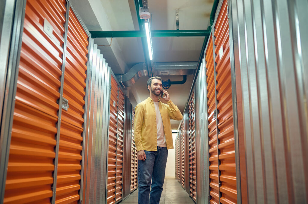 Man talking on smartphone in storage facility